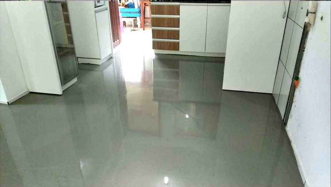 Contrapiso nivelado e liso, ainda sem piso, refletindo a luz do ambiente